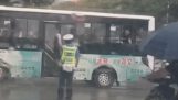 버스 승객은 교통 관리인에게 우산을 제공합니다.