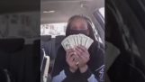 En kvinna visar upp sina pengar