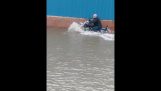 Traversa un drum inundat pe o motocicletă