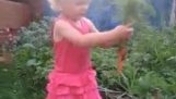 Kis orosz lány betakarító sárgarépa, és azt mondja blyat