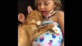 En liten jente synger å sette henne katten å sove