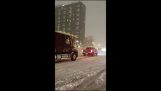 A pickup tows a truck in the snow