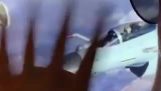 Plane passenger waves to a fighter jet pilot