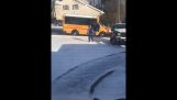 A schoolboy must face the ice to get on a school bus