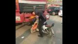 Man headbutting камион на неговия скутер