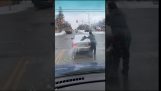 Guy tisztítja a hátsó ablak elöl autóval hó