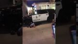 Agente di polizia si copre la testa con un bidone della spazzatura
