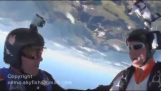 Skydiver opens the parachute just in time to avoid crashing against a mountain
