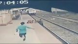 A railwayman saves a fallen child on the rails