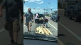 Kolemjdoucí řidiči pomáhají vyzvednout spadnuté dřevo na silnici