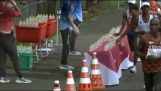 Een marathonloper laat alle flessen vallen uit het verfrissingsstation
