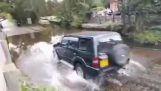 Biker comes speeding a t a flooded road