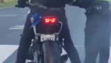 Miły policjant pomaga motocyklistce w wypaleniach