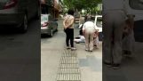 A cop hits a woman with her baby