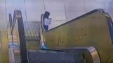 فتاة صغيرة ينجرف من الدرابزين من السلالم المتحركة
