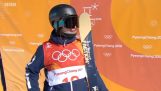 Um esquiador cumprimenta a câmara para os Jogos Olímpicos