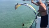Parachutist krijgt een biertje van een balkon