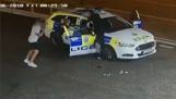 Matón tratando de robar el coche de policía por dos policías
