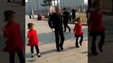 A grandfather dancing shuffle along with his granddaughters