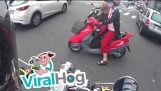 Um carro recebe uma mulher em um scooter