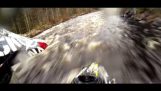 Snøscooter går oppstrøms i en elv