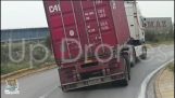 Kuorma-auton renkaat halkeilevat kuljettaa kontit Pireuksen sataman