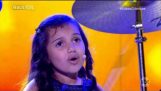 Een 7-jarige meisje speelt toxiciteit op drums en zingt op hetzelfde moment
