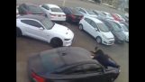 Продавач на автомобили виси на капака на автомобила, тъй като е откраднат
