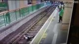 Kvalmende øyeblikk renere er dyttet på toget spor av pendler
