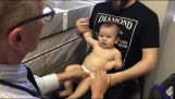 Børnelæge distrahere en baby før injektion