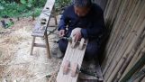 Дедушка строит деревянный самокат своего внука