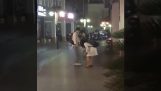 Homem ajuda a sua esposa para transportar um recipiente de água