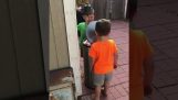 Two children playing with trash bin