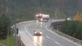 Kollision mit dem Auto wirft einen LKW unter der Brücke