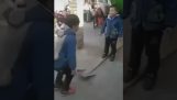 Två små barn som leker med en spade