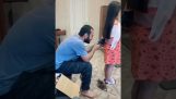 Tata constructor își taie părul fiicei sale