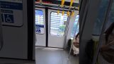 आवासीय क्षेत्र से गुजरते समय धुंधली खिड़कियों के साथ ट्रेन