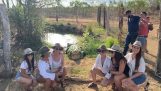 Turiști care pozează în fața unui crocodil