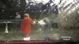 A man defends himself with a pressure washer