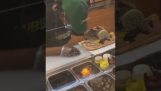 Ein Restaurantangestellter schläft ein, während er ein Sandwich macht