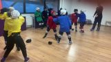 Un entrenador de hockey muestra a los niños cómo golpear
