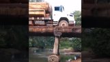 Um caminhão passa por uma ponte de madeira
