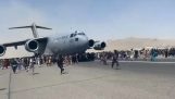 아프간인들이 카불 공항에서 이륙하는 비행기에 탑승하려고 합니다.
