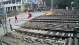 Huolimaton moottoripyöräilijä ylittää junan raiteet