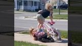 A little girl helps her friend get on the bike