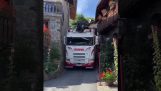 Lumber truck passes through a very narrow road